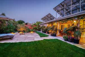 flagstone paver patio with greenery and outdoor lighting